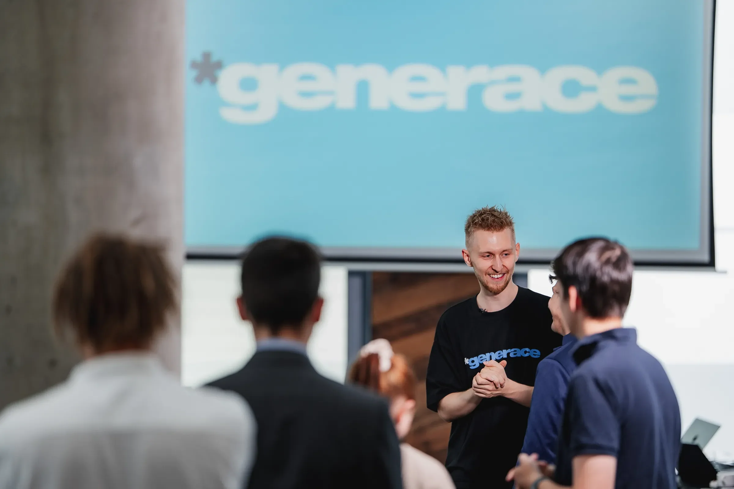 Daniel Krutý mit Gästen unter der Leinwand mit dem Generace-Logo