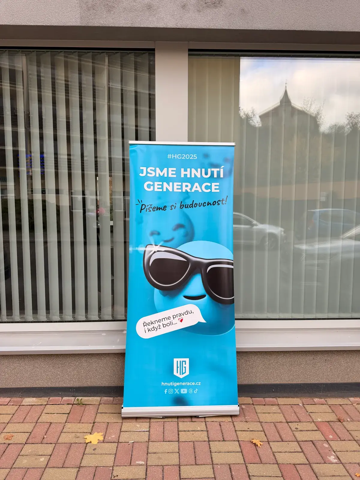 Das gedruckte Roll-up von Hnutí Generace mit dem Smiley vor einem Gebäude